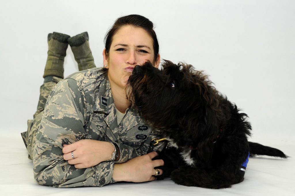 Capt. Carmella Burruss, 22nd Operations Support Squadron deputy chief of wing intelligence, poses for a photo with Valco, May 25, 2016, at McConnell Air Force Base, Kan. Valco is a Labrador-Poodle mix who has been training with Burruss to get his certification from Therapy Dog International so he can work in Veterans Affairs hospitals. (U.S. Air Force photo/Airman 1st Class Jenna K. Caldwell)