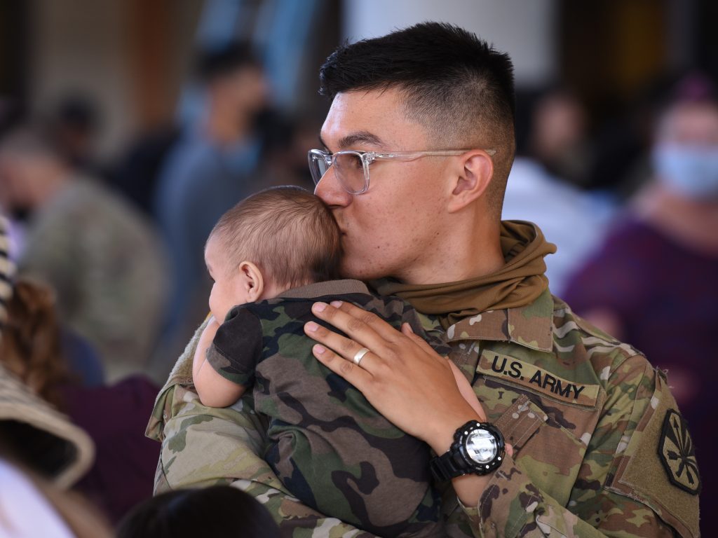 Arizona Army National Guard Spc. Samuel Rodriguez, a multichannel transmission operator with A Company, 422nd Expeditionary Signal Battalion, softly kisses his two-month-old son’s head, while spending his last few hours in Arizona with family May 2, 2021, at Papago Park Military Reservation in Phoenix. This is Rodriguez’s first deployment away from his family, where he and his unit will support Operation Inherent Resolve and Operation Spartan Shield in Middle East for nine months. (Arizona Army National Guard photo by Sgt. 1st Class Brian A. Barbour)